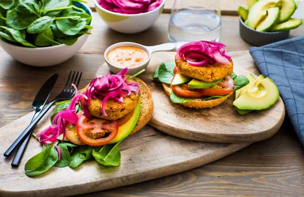 Åpen vegetarburger med syltet rødløk, avokado og paprikadressing