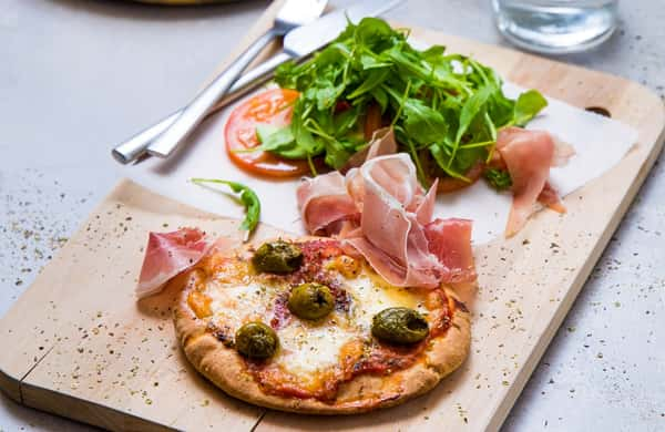 Fullkornspitapizza med parmaskinke og avokado- og ruccolasalat